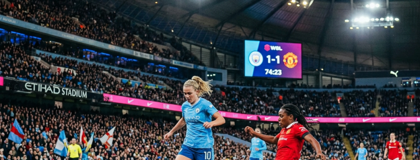Two women soccer players contesting the ball near the edge of the pitch in a stadium during a 1-1 WSL match